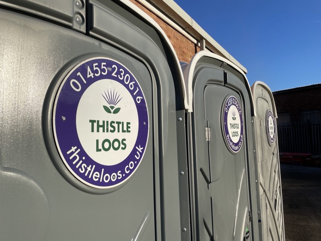 close up of thistle loos portable toilets outside