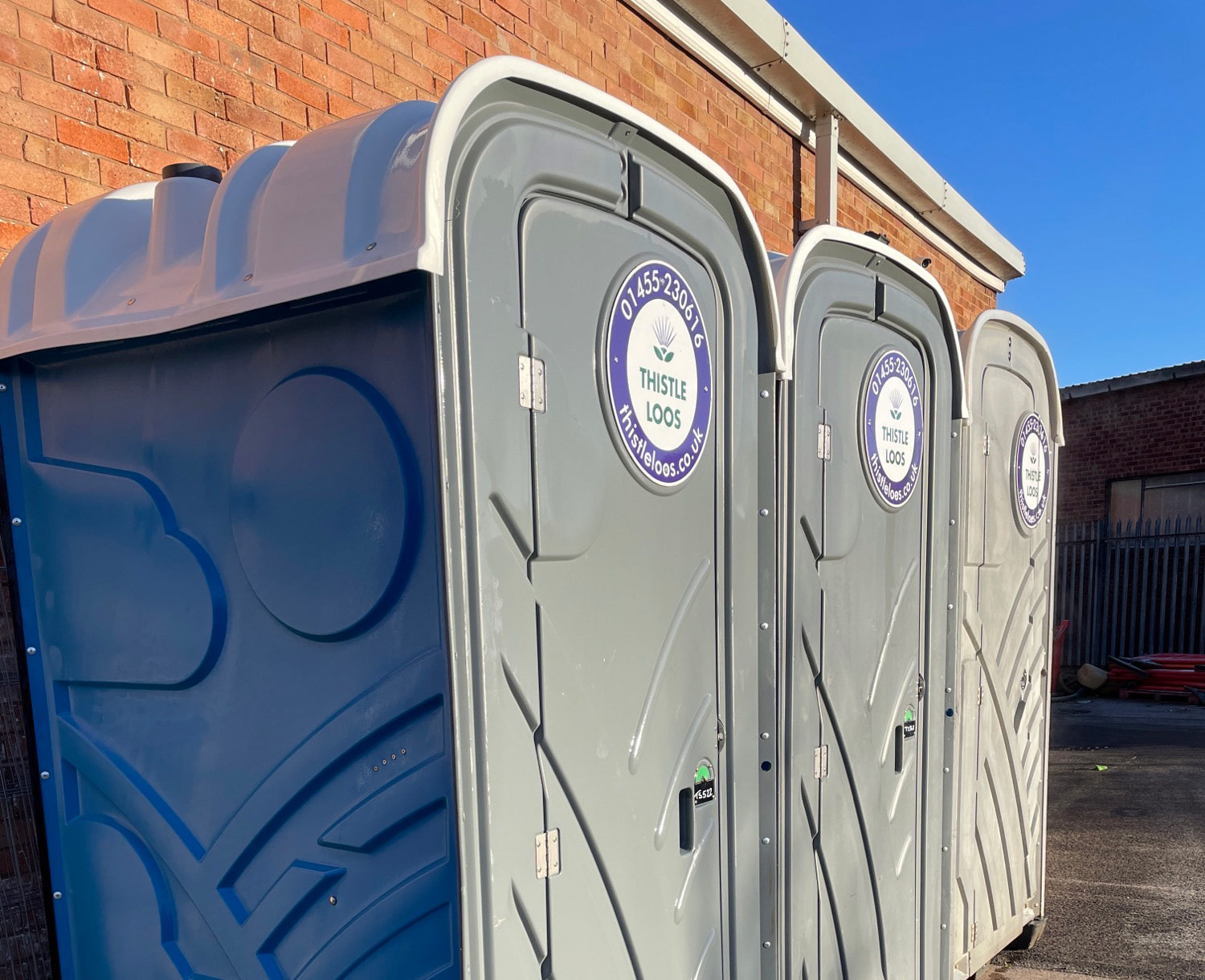 Thistle Loos portable toilets in a line outside