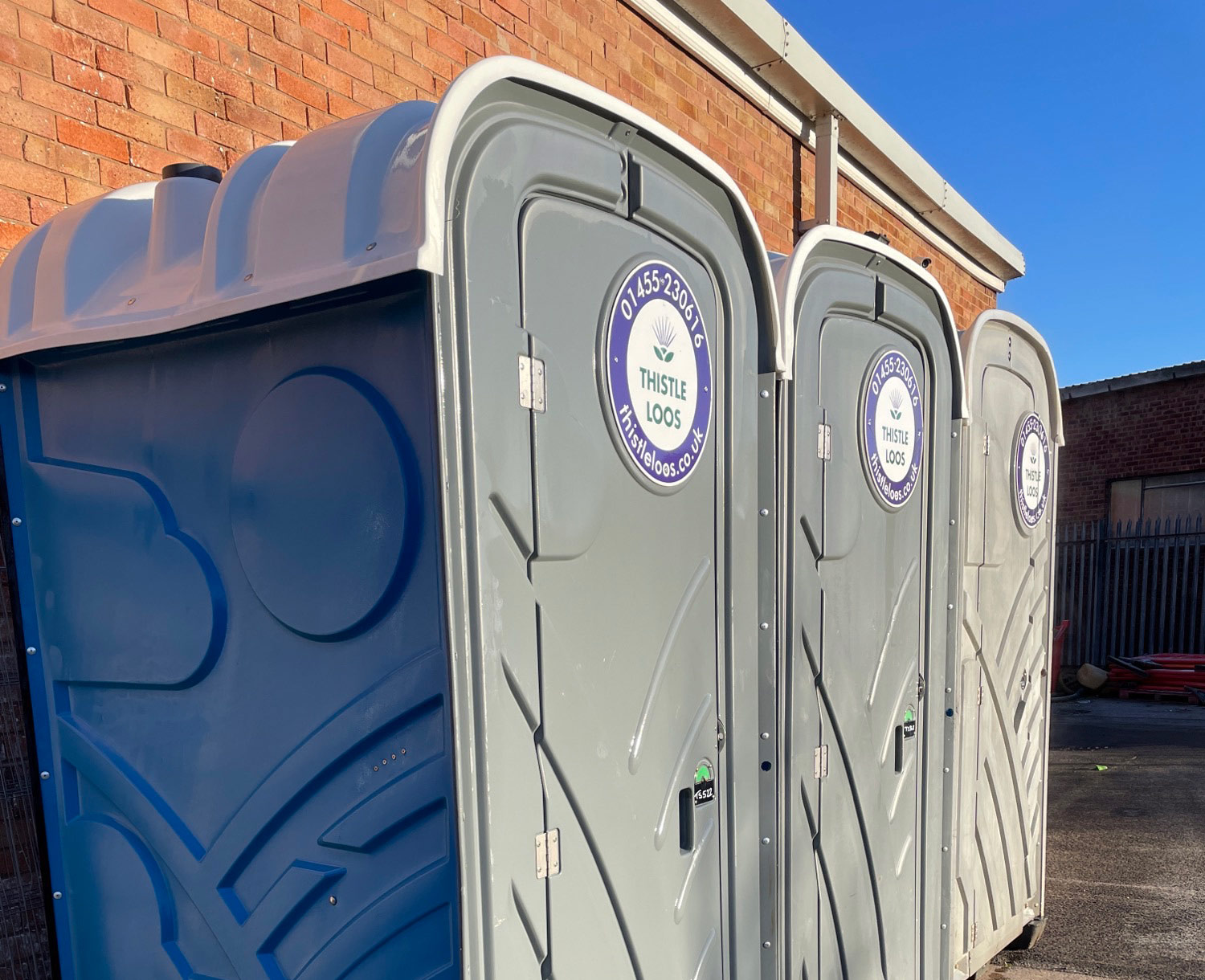 Thistle Loos portable toilets in a line outside