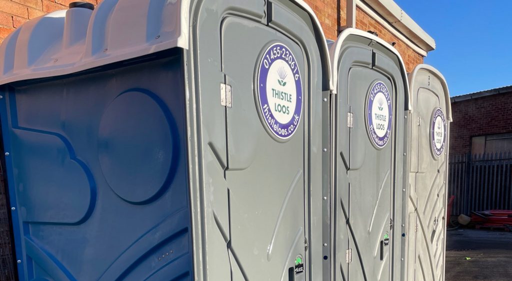 Thistle Loos portable toilets in a line outside